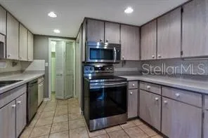 a kitchen with stainless steel appliances granite countertop a stove a sink and a microwave
