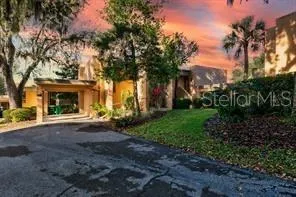 a view of a house with a garden and trees