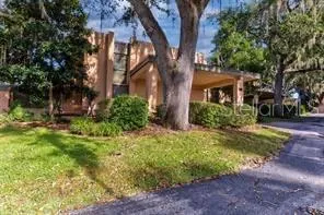 a view of a house with a tree in the yard