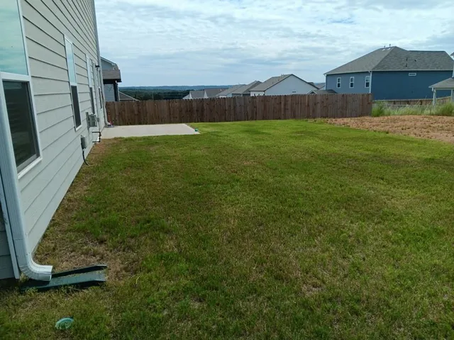a view of an house with backyard and tub