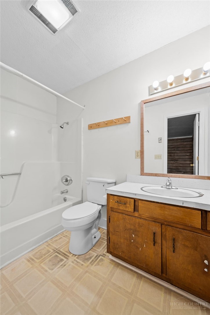 233 Alpine Acres Road Vilas, NC 28692 - Photo 15 of 32 a spacious bathroom with a toilet sink and mirror
