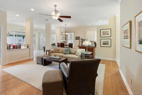 a living room with furniture kitchen area and a wooden floor