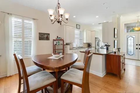 a kitchen with stainless steel appliances a dining table chairs and a refrigerator