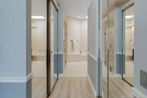 a bathroom with a tub a sink double vanity and mirror