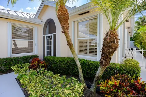 a view of a hallway with windows and chandelier