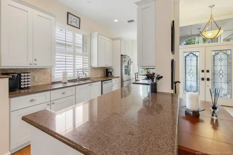 a large kitchen with stainless steel appliances lots of counter space and a sink