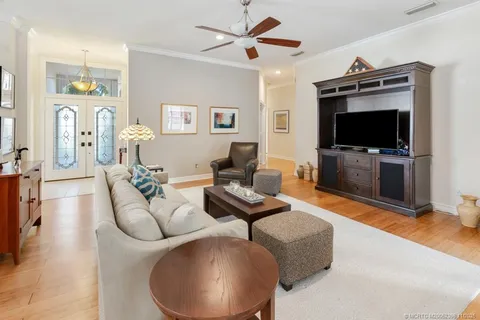 a living room with furniture a flat screen tv and kitchen view
