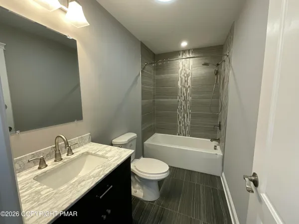 a bathroom with a shower a sink a toilet and a mirror