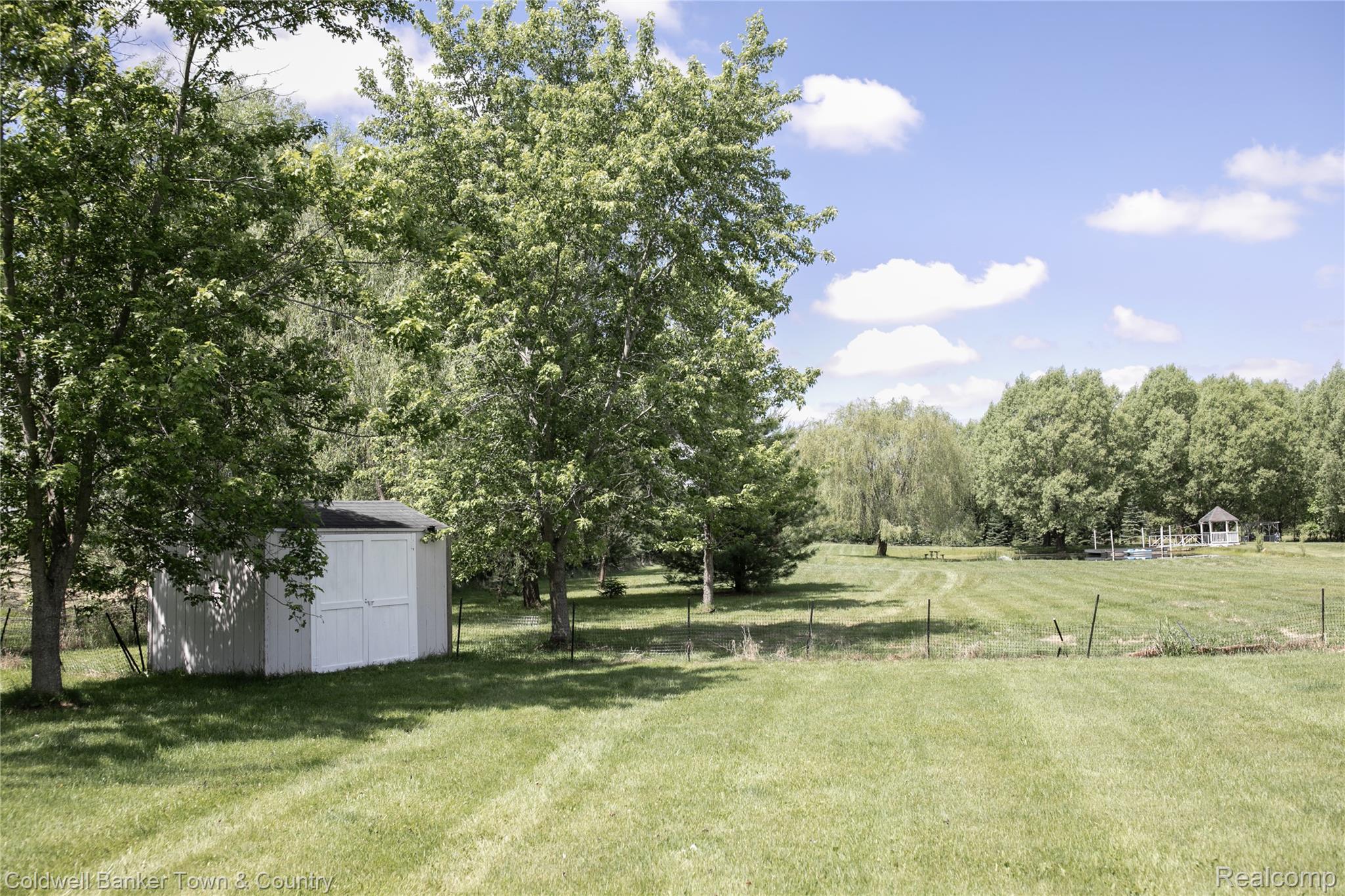 717 North Youngs Road Attica, MI 48412 - Photo 9 of 87 Expansive grassy landscape featuring a white storage shed and numerous mature trees