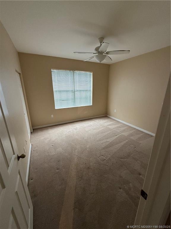 225 Southeast Kitching Circle Stuart, FL 34994 - Photo 22 of 24 an empty room with windows and fan