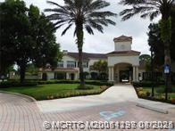 225 Southeast Kitching Circle Stuart, FL 34994 - Photo 3 of 24 a view of a white house with a yard and potted plants