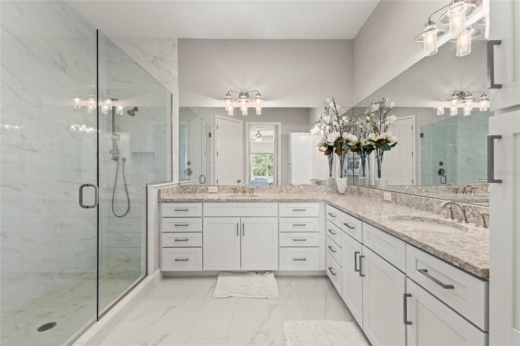 295 Compass Point Drive, Unit 202 Bradenton, FL 34209 - Photo 25 of 100 a spacious bathroom with a granite countertop sink a mirror and a shower