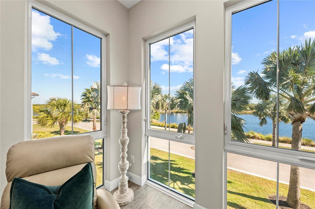 295 Compass Point Drive, Unit 202 Bradenton, FL 34209 - Photo 30 of 100 a living room with furniture and a floor to ceiling window