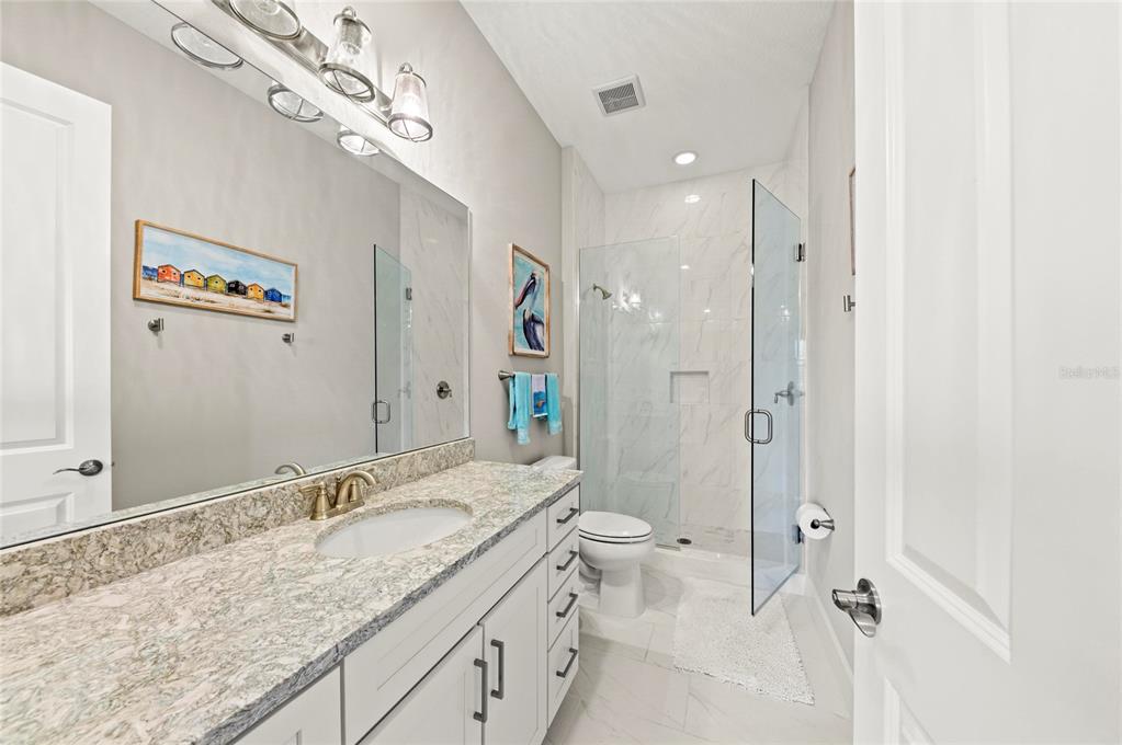 295 Compass Point Drive, Unit 202 Bradenton, FL 34209 - Photo 37 of 100 a bathroom with a granite countertop sink a toilet and a shower