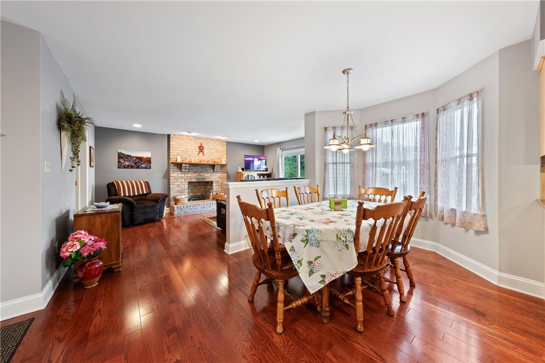 4568 Greenfield Road Bethlehem, PA 18017 - Photo 15 of 59 Rich hardwood floors unite an inviting dining space with a cozy living area featuring a brick fireplace.