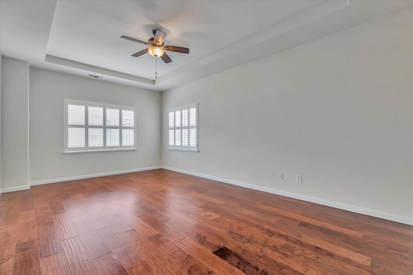 5175 Trinity Park Drive Alviso, CA 95002 - Photo 13 of 24 an empty room with wooden floor chandelier fan and windows