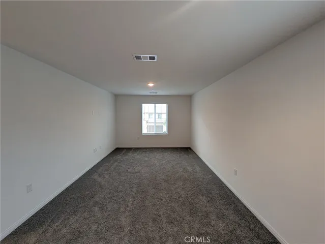 a view of a kitchen with a refrigerator and a wooden cabinets