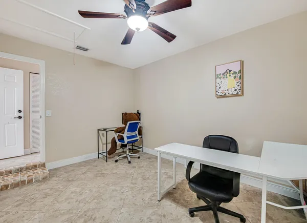 a view of a workspace with furniture and a fan