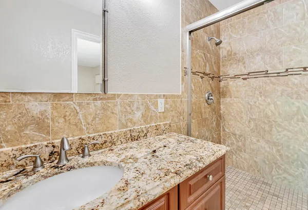 a bathroom with a granite countertop sink and a mirror