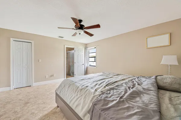 a bedroom with a large bed and a chandelier