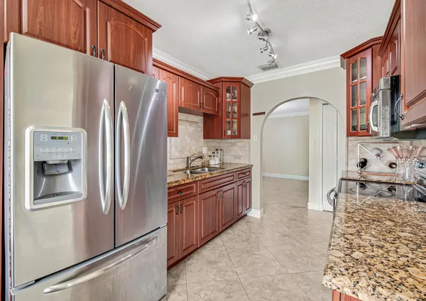 a kitchen with stainless steel appliances granite countertop a refrigerator and a stove
