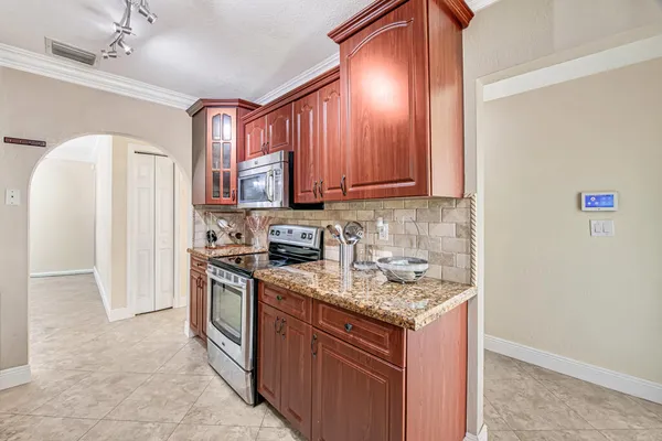a kitchen with stainless steel appliances granite countertop a stove a refrigerator and a sink