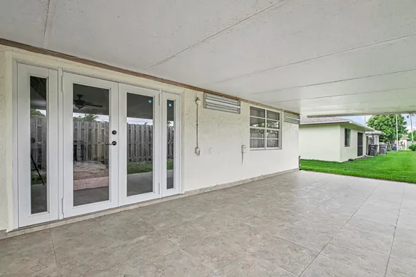 a view of a house with a big yard and potted plants