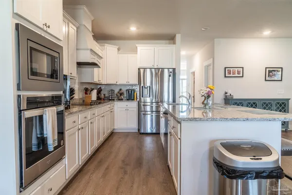a kitchen with stainless steel appliances a sink stove refrigerator and cabinets