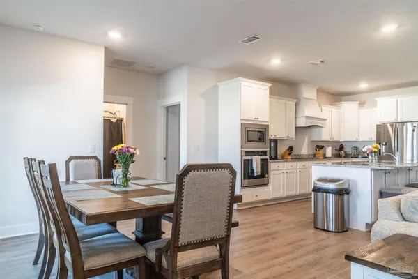 a dining room with furniture and wooden floor