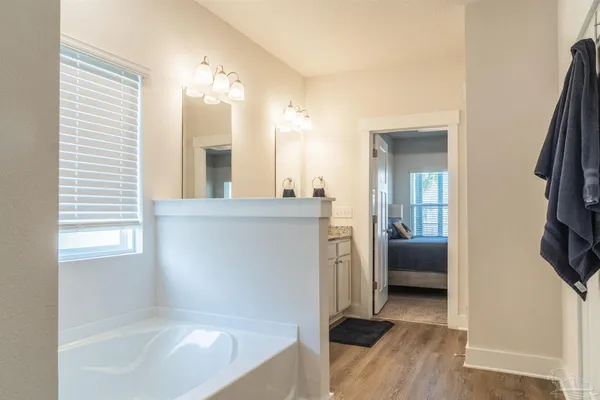 a en suite bathroom with a tub sink and mirror
