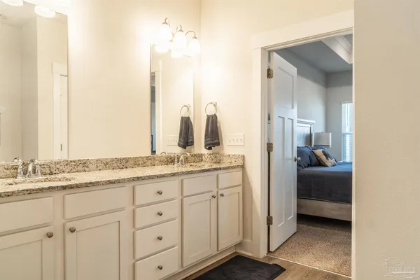 a en suite bathroom with a granite countertop sink and a mirror