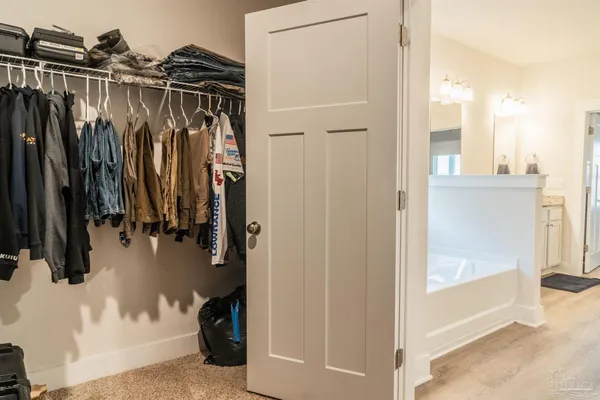 a view of walk in closet with clothes and shoes
