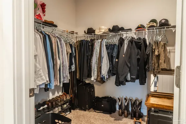 a view of walk in closet with clothes and shoes