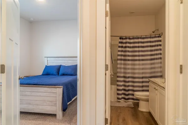 a bathroom with a granite countertop sink mirror vanity and toilet