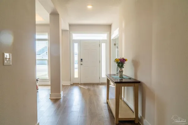 a view of a hallway with wooden floor and furniture