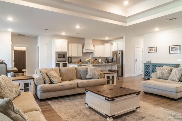 a living room with furniture and a view of kitchen