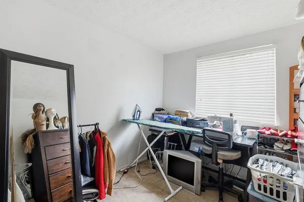 a view of a workspace with furniture and a window