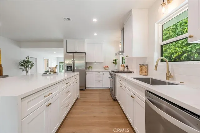 a kitchen with white cabinets and white appliances