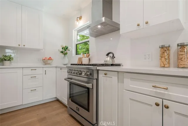 a kitchen with a stove and white cabinets