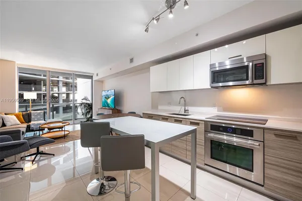 a kitchen with a stove a microwave and wooden floor