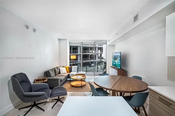 a living room with furniture and a floor to ceiling window