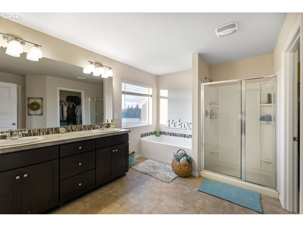 3512 North 10th Street Ridgefield, WA 98642 - Photo 16 of 23 a bathroom with a tub a double vanity sink and a mirror
