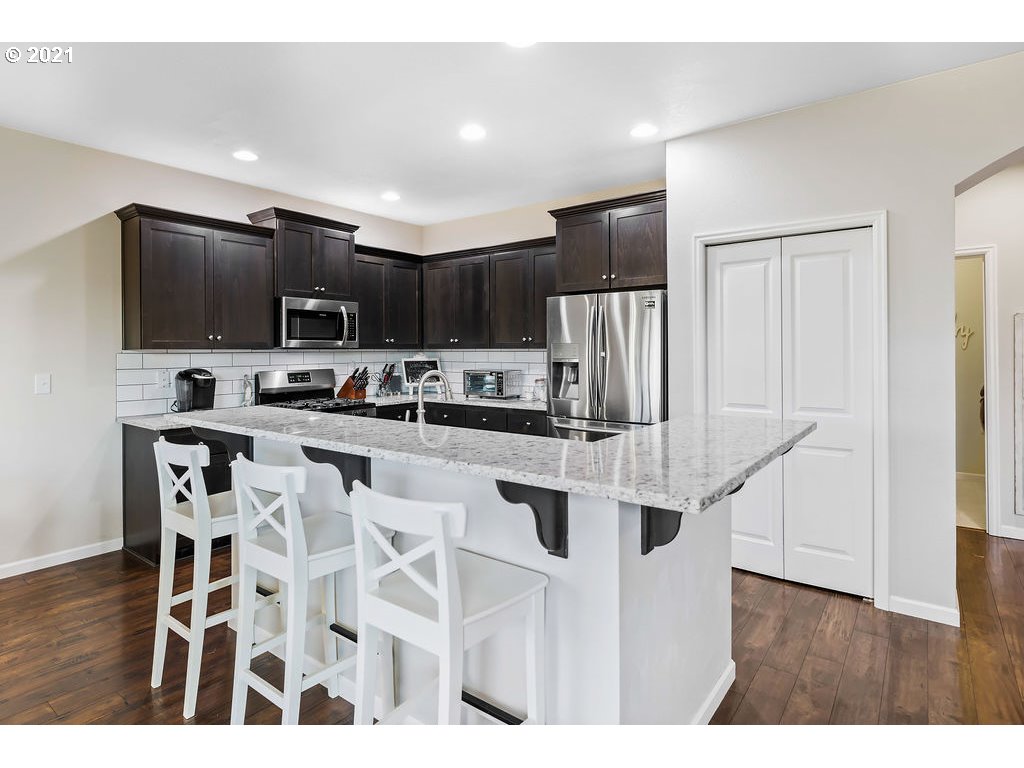 3512 North 10th Street Ridgefield, WA 98642 - Photo 5 of 23 a kitchen with stainless steel appliances kitchen island granite countertop a refrigerator and a stove top oven