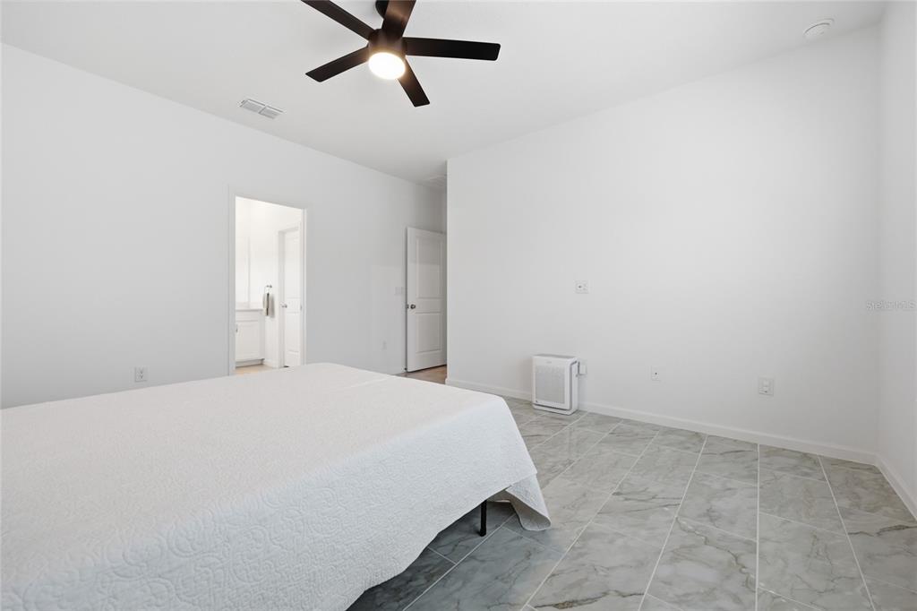 511 Northwest 4th Street Williston, FL 32696 - Photo 20 of 33 a bedroom with a bed and a chandelier fan