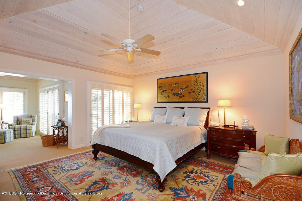 400 Caribbean Road Palm Beach, FL 33480 - Photo 12 of 45 a bedroom with a bed and wooden floor