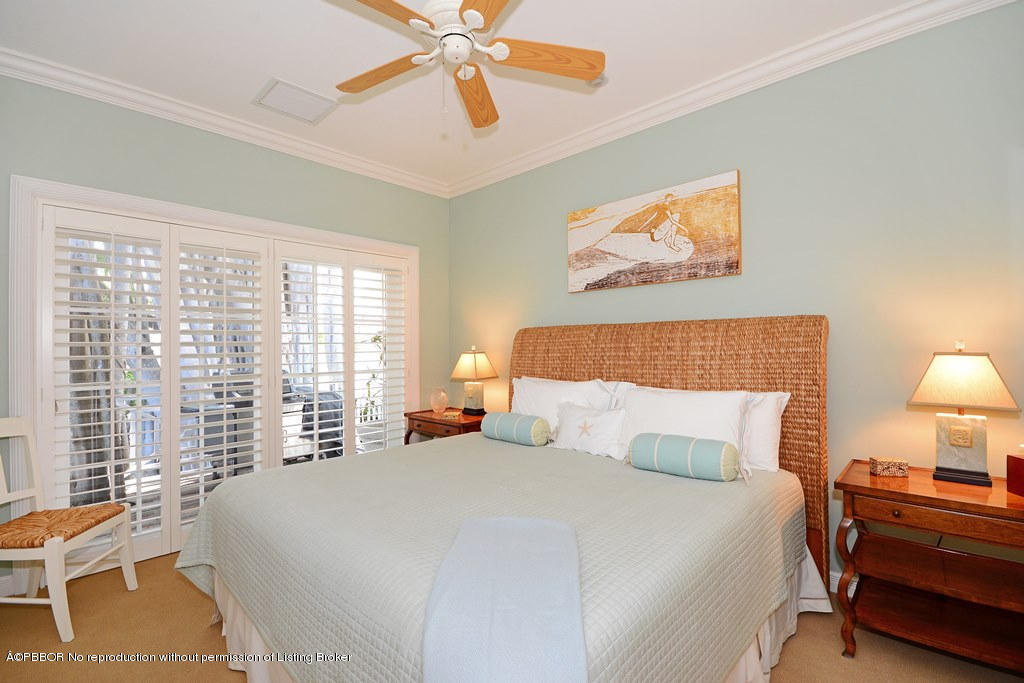 400 Caribbean Road Palm Beach, FL 33480 - Photo 27 of 45 a bedroom with a bed and a chandelier