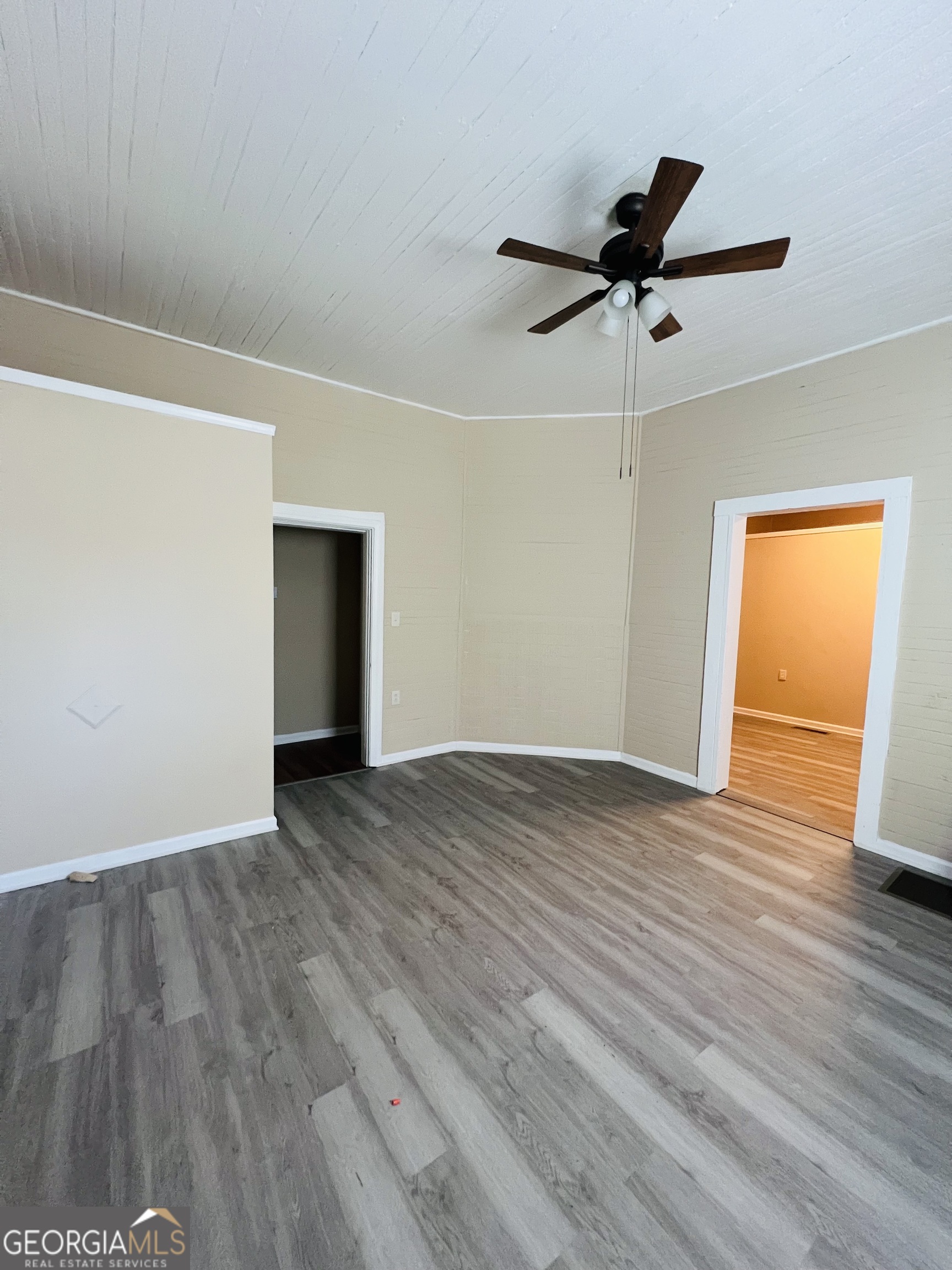 101 McGee Street LaGrange, GA 30241 - Photo 5 of 15 an empty room with wooden floor a ceiling fan and windows