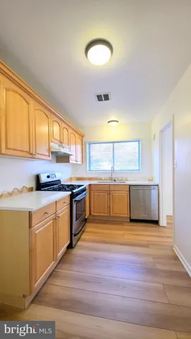 a kitchen with stainless steel appliances wooden cabinets and a stove top oven