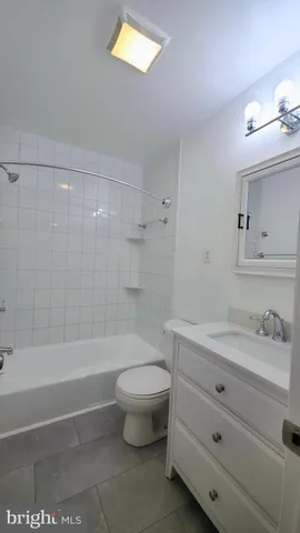 an empty room with wooden floor and a ceiling fan