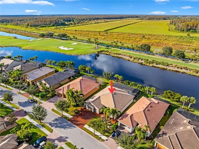 an aerial view of ocean and residential houses with outdoor space